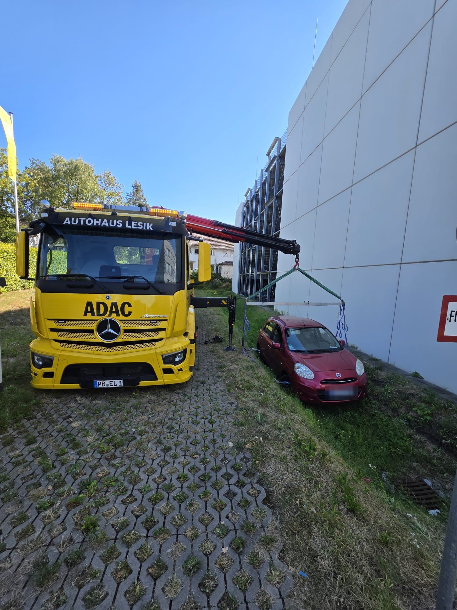 Abschleppwagen von Autohaus Lesik hebt mit dem Kran ein Auto aus dem Graben