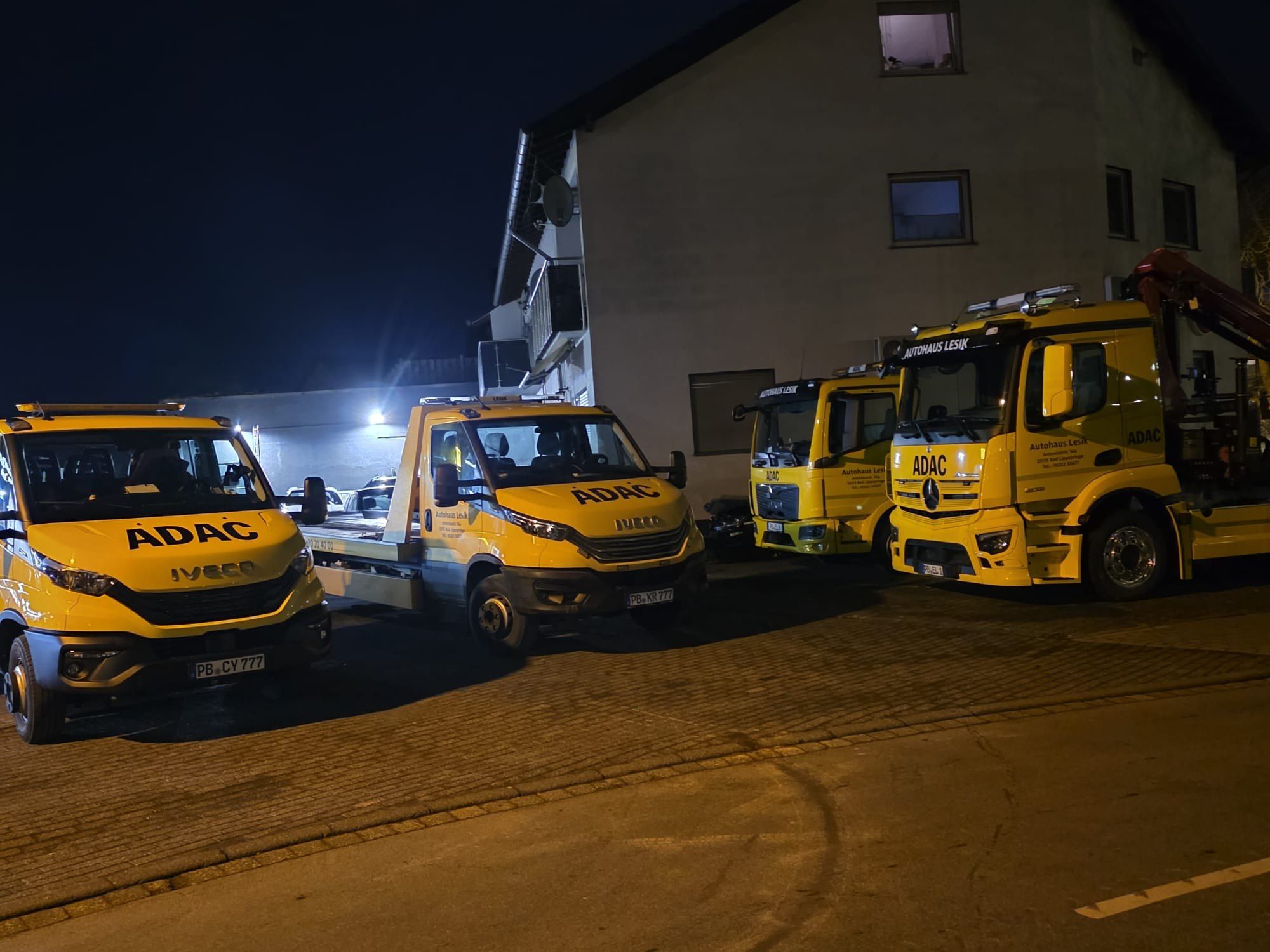 Die Abschleppwagen von Autohaus Lesik nachts auf dem Hof